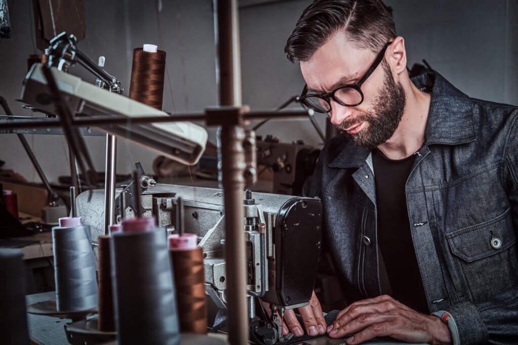 Croitore lucrând la mașina de cusut industrială.