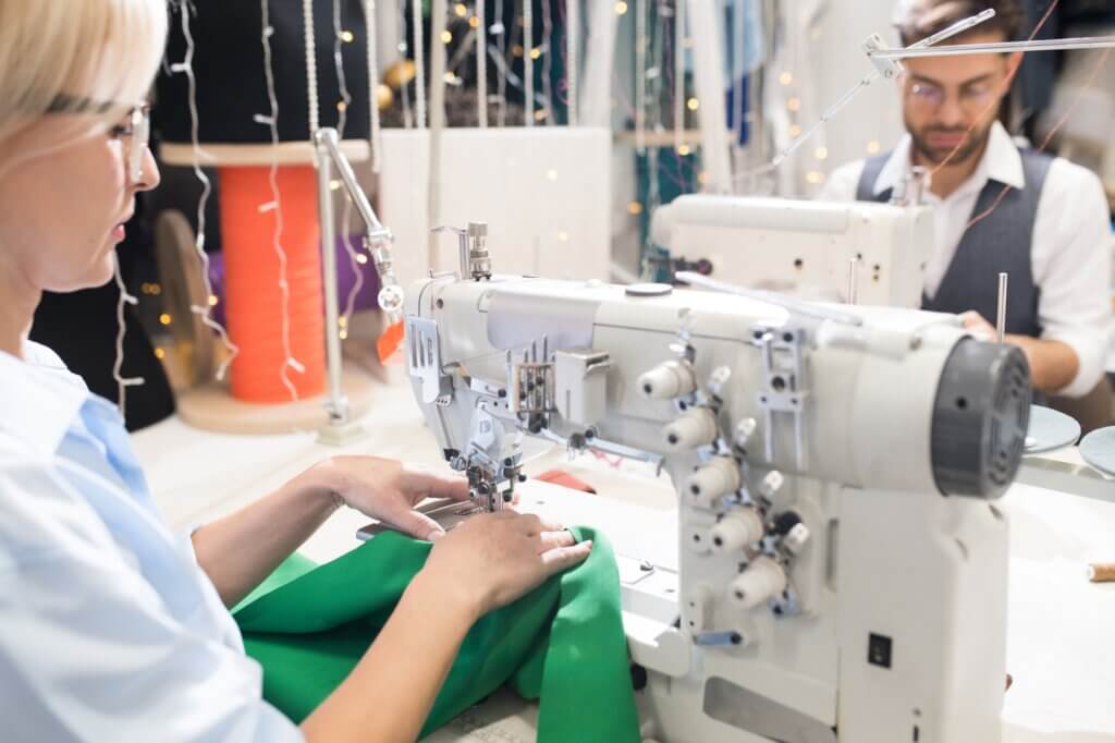 Croitoreasă la mașină de cusut în atelier